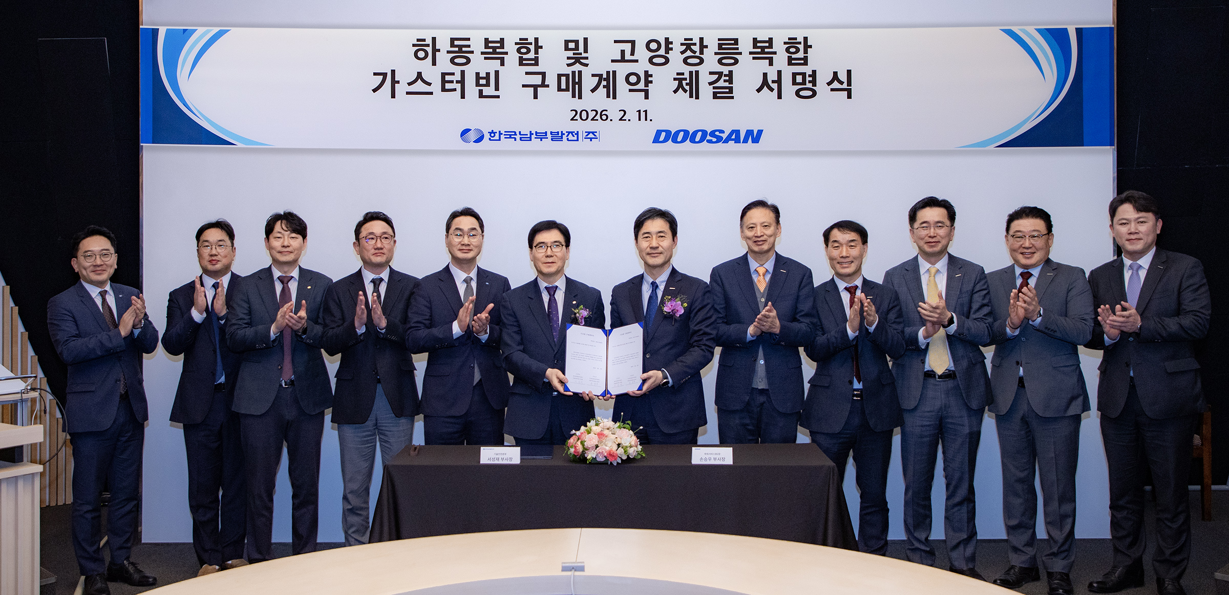 ▲ On Feb 11, Sungjae Seo, Executive Director of KOSPO’s Engineering Safety Division (6th from the left), and Seungwoo Sohn, CEO of Doosan Enerbility’s Power Services BG (7th from the left), pose with the related parties for a group photo at the signing ceremony held at Doosan Enerbility’s Changwon headquarters regarding the supply of three gas turbines.
