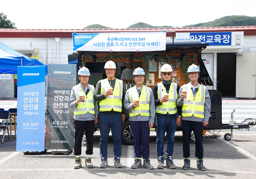 경남 합천군에 위치한 함양-창녕간 고속도로 건설현장에서 두산에너빌리티와 협력사 직원들이 커피차 앞에서 기념촬영을 하고 있다.