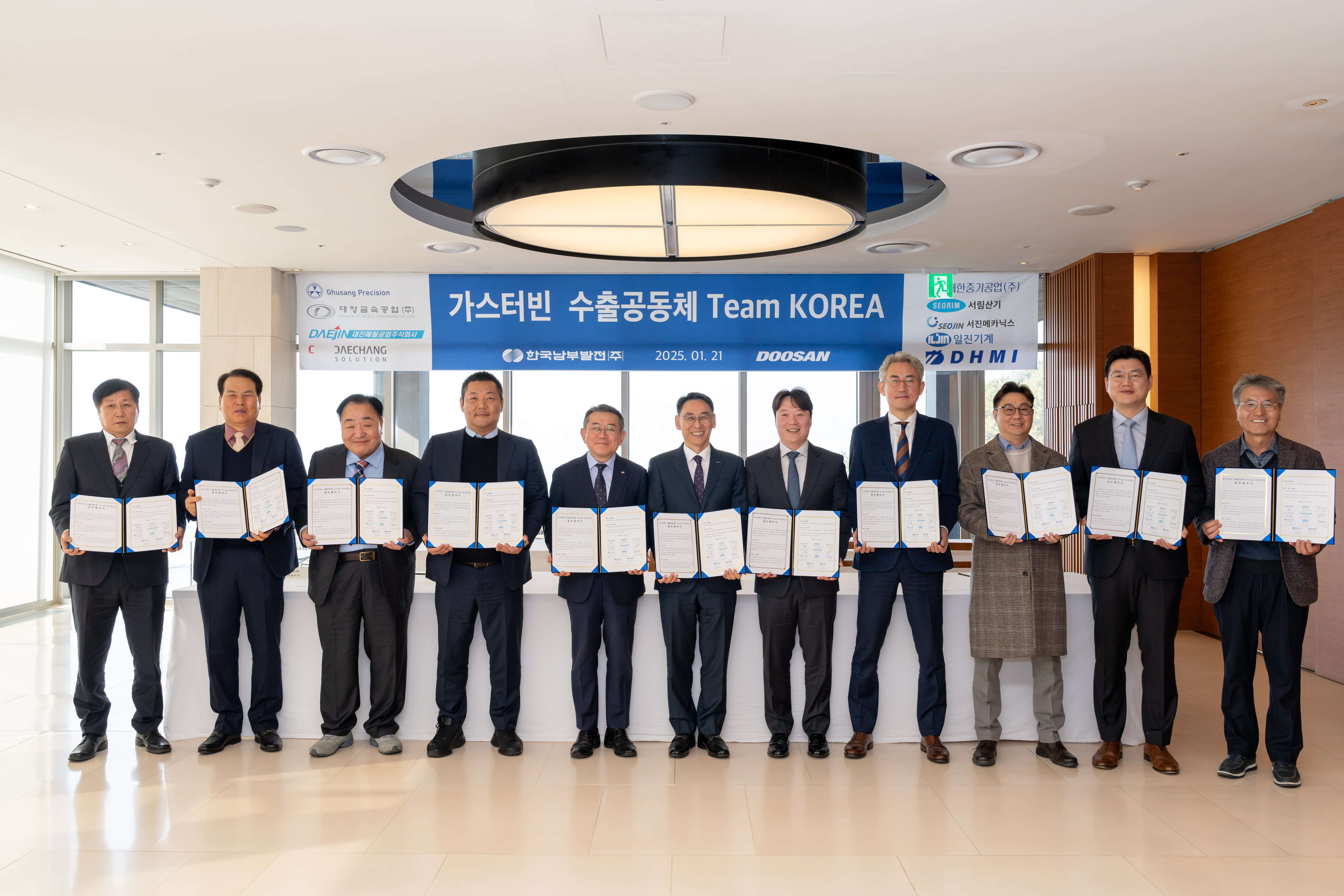 21일 두산에너빌리티 창원 본사에서 진행된 ‘가스터빈 수출공동체 팀 코리아’ 업무협약식에서 한국남부발전 김준동 사장(왼쪽 5번째)과 두산에너빌리티 정연인 부회장(왼쪽 6번째)이 국내 협력사 대표들과 기념촬영을 하고 있다.