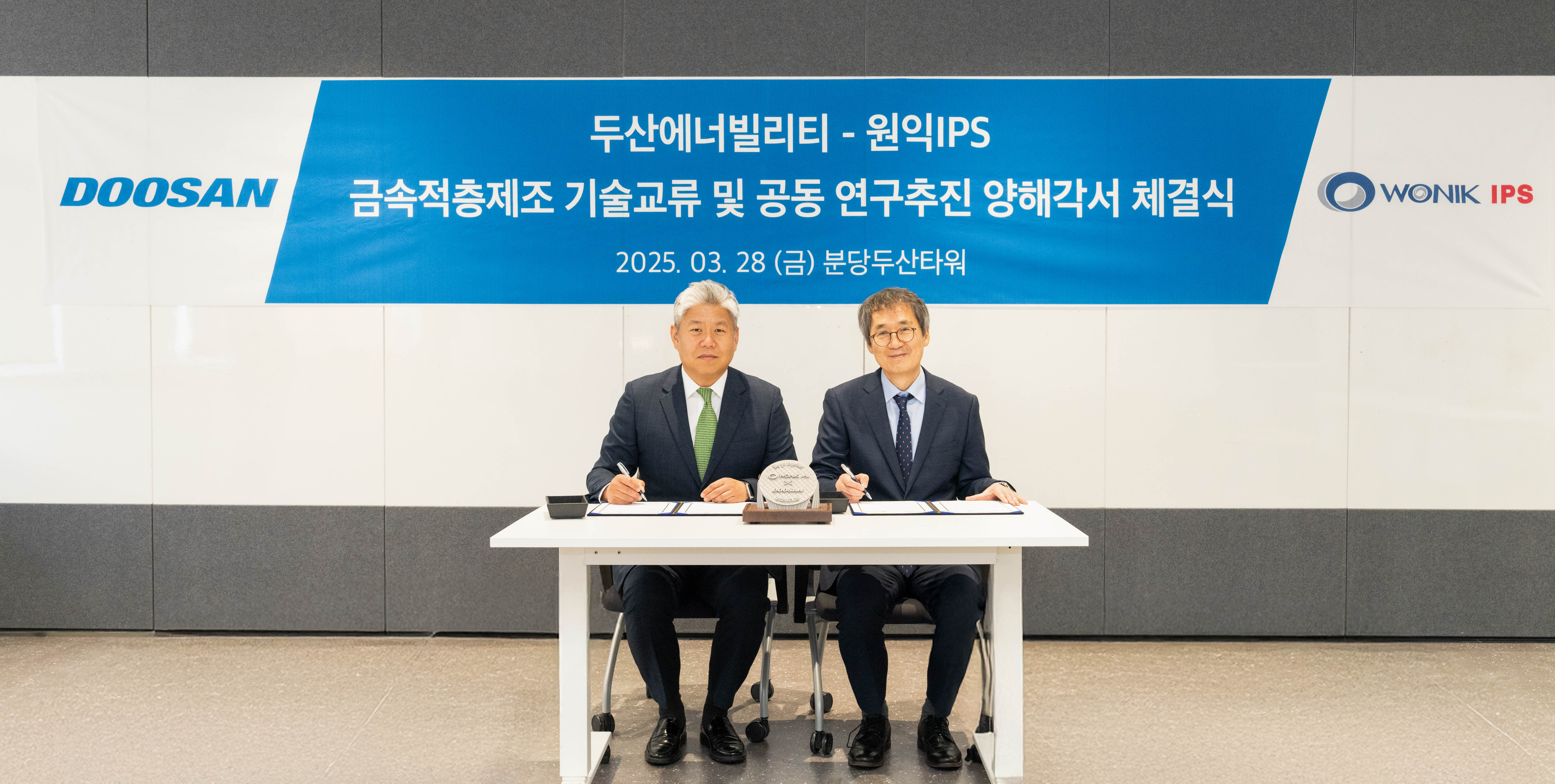 ▲ 지난 28일 경기도 성남시 분당두산타워에서 열린 ‘적층제조 기술 교류 및 연구 추진’ 양해각서(MOU) 체결식에서 두산에너빌리티 이희범 전략/혁신 담당(왼쪽)과 원익IPS 이명범 선행개발본부 총괄이 서명하고 있다. 